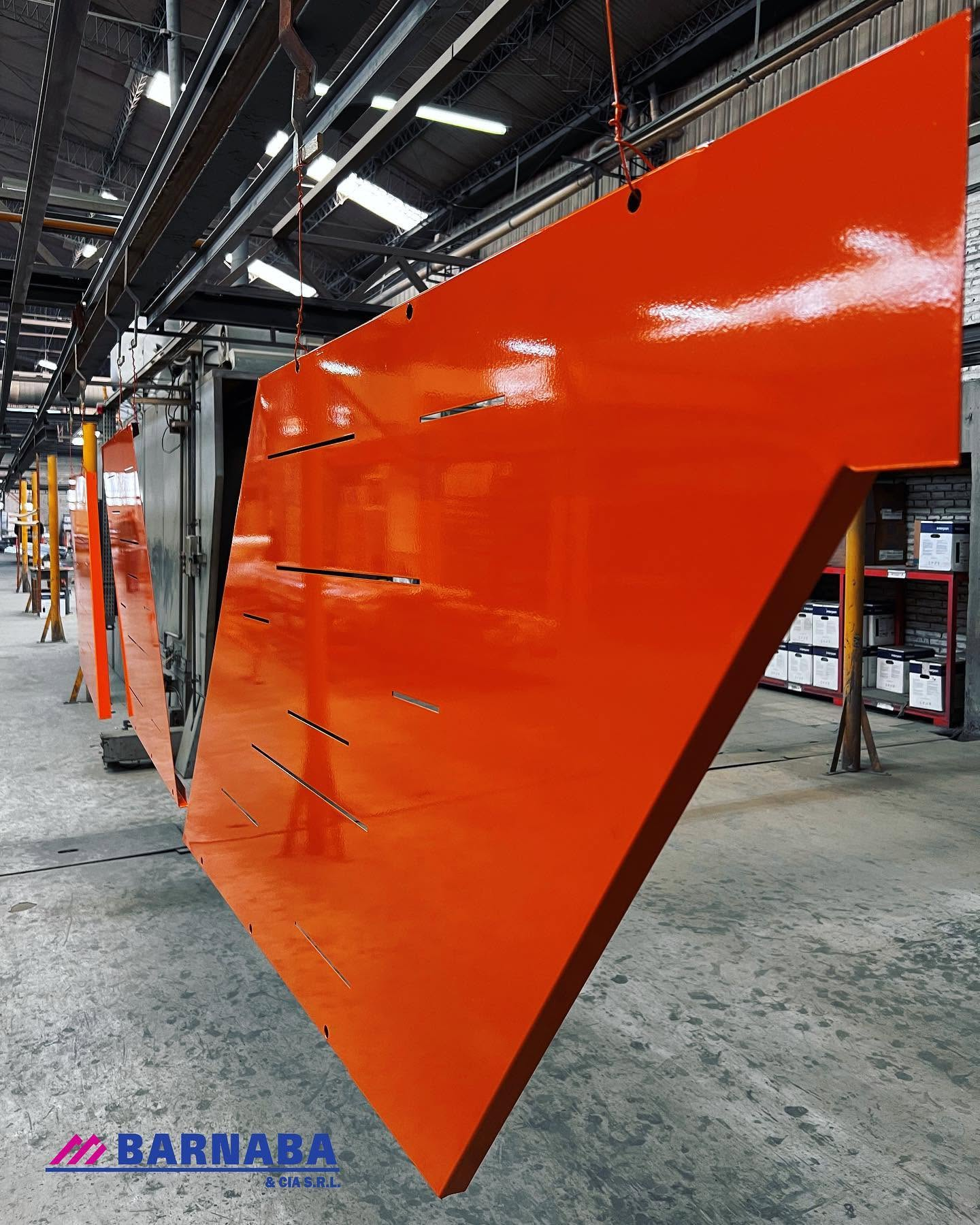 Panel de aluminio esmaltado en naranja saliendo de la línea de curado