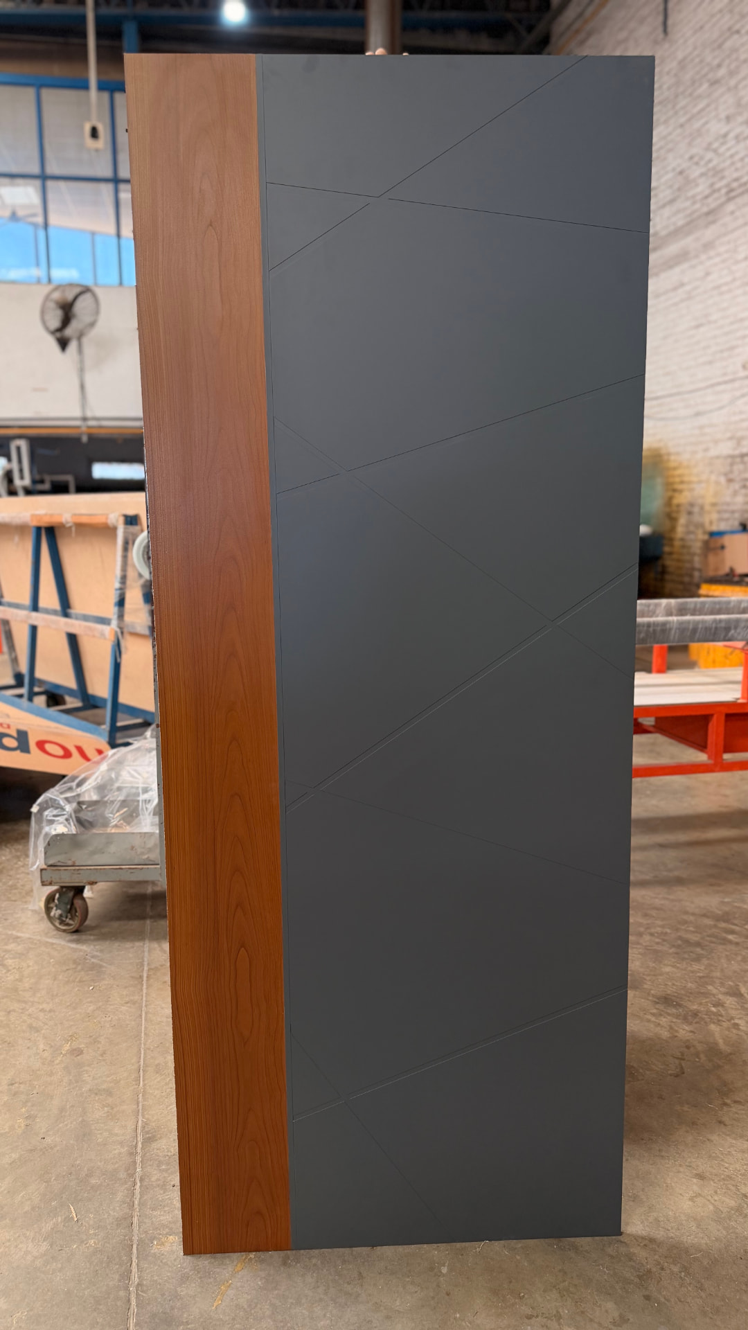 Placa combinada de 800 × 2000 mm con marco símil madera cedro e inserto gris ruteado, vista frontal en la planta